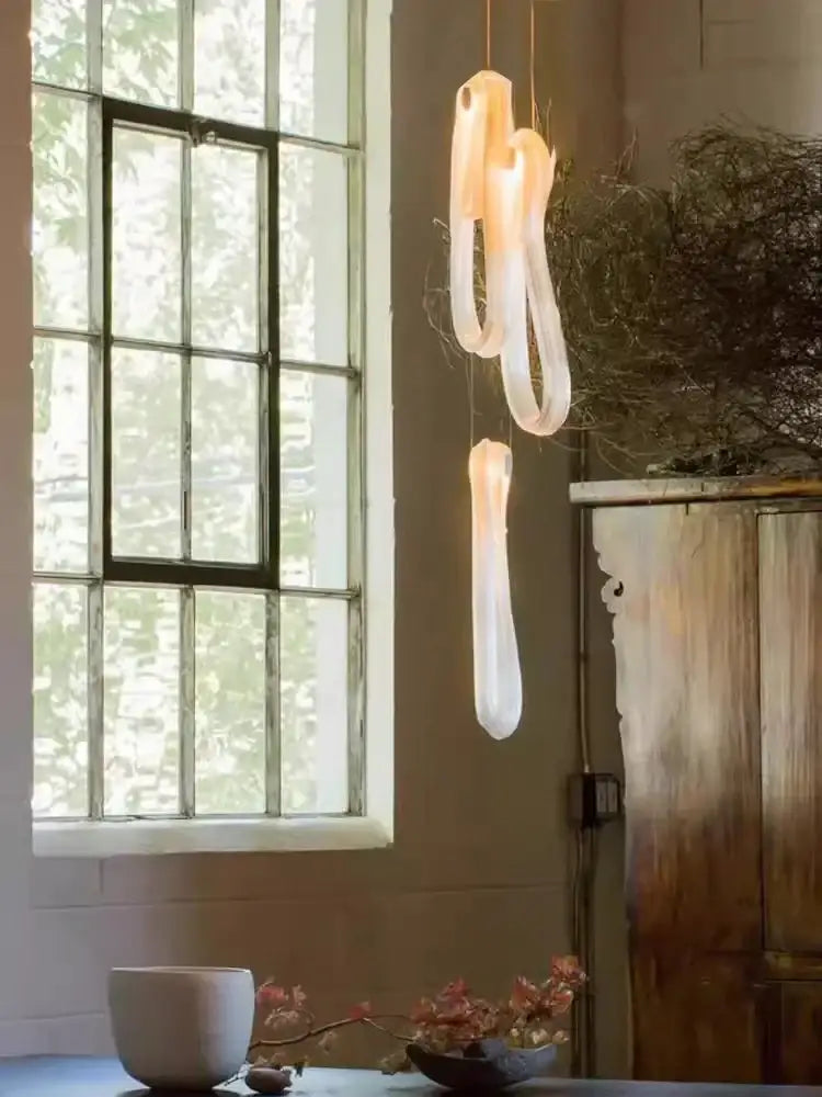 A modern minimalist elegant led glass chandelier with translucent white organic shapes for dining room lighting