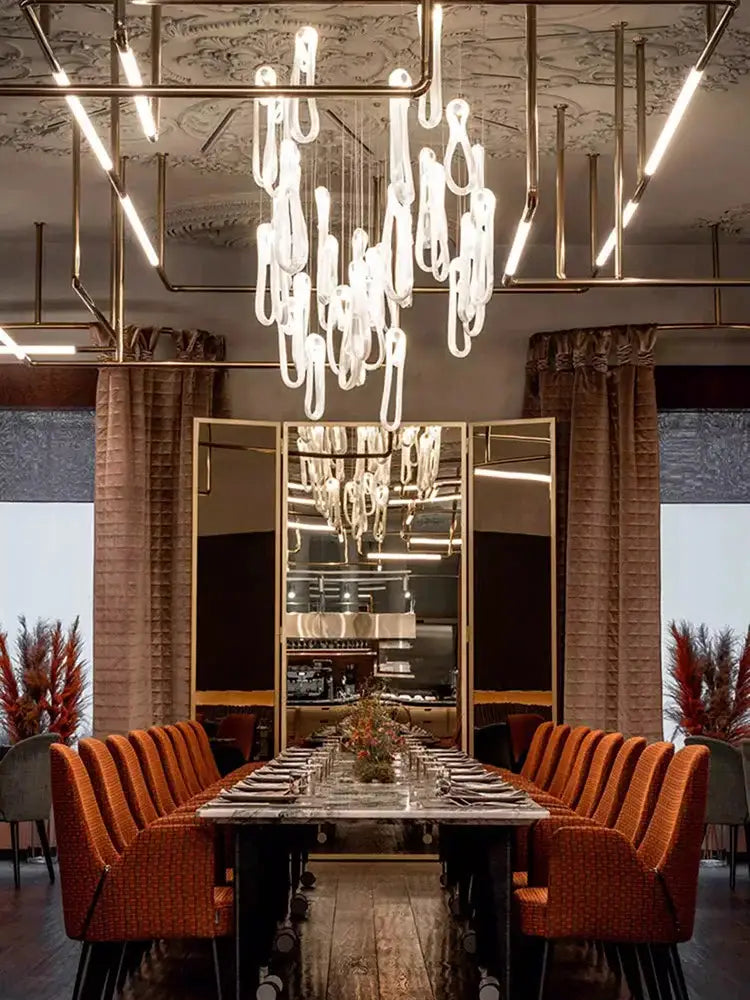 A modern minimalist elegant led glass chandelier with translucent teardrop glass elements for dining room lighting
