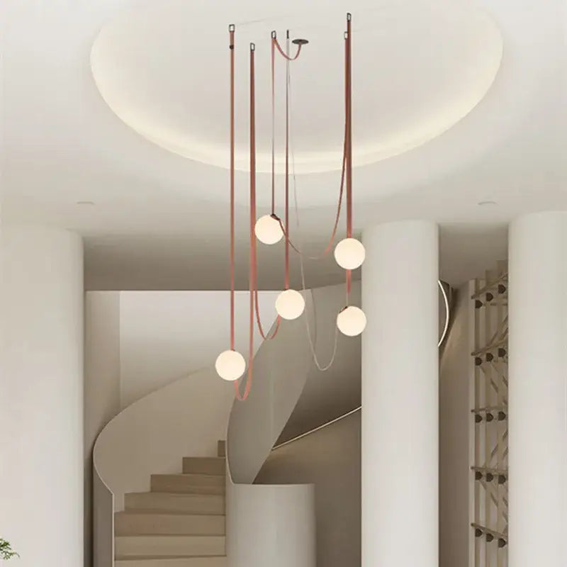 Modern minimalist pendant light with five copper-toned cords and frosted glass ball bulbs for dining room decorbites glass ball