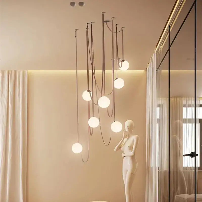 Modern minimalist pendant light with multiple frosted glass ball bulbs suspended by dark metal cords for dining room decorbites glass ball