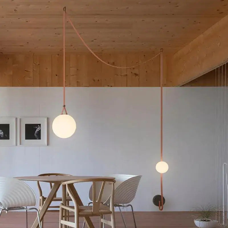 Modern minimalist frosted glass ball pendant light with warm glow and copper-toned cords for dining room decorbites glass ball pendant light