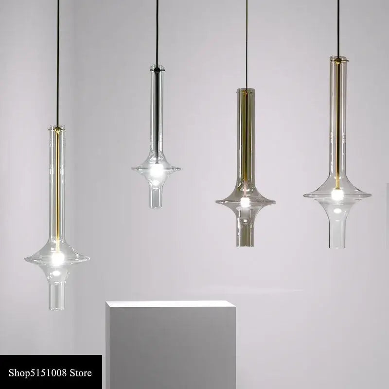 Four modern minimalist glass pendant lights with gold-toned accents and black cords for kitchen hanging lamps