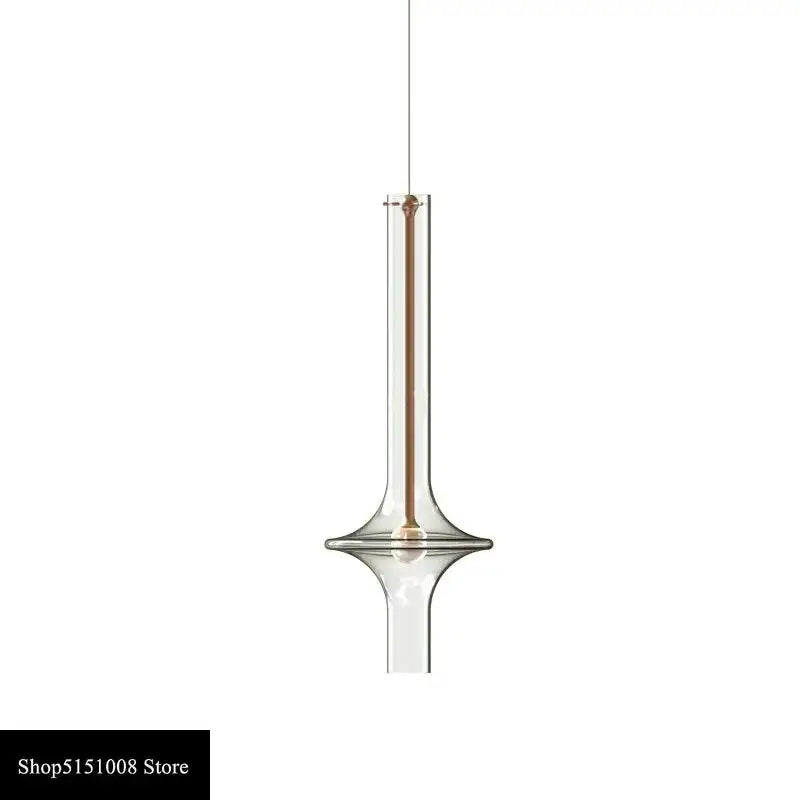 Modern minimalist glass pendant light with a slender transparent body and warm metallic accent for kitchen use
