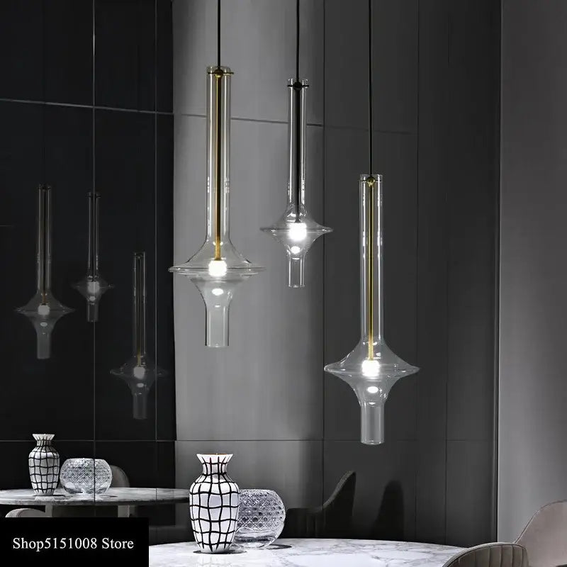 Three modern glass pendant lights with clear shades and gold-toned metal accents for kitchen lighting