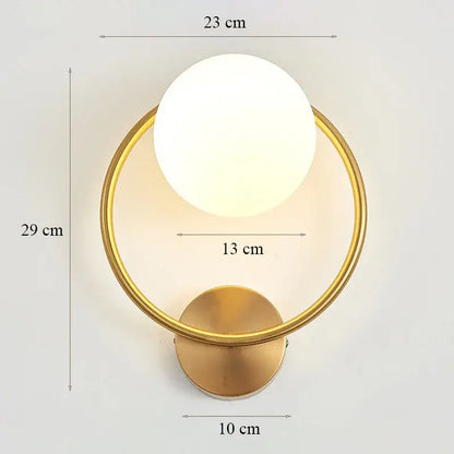 Modern minimalist wall lamp featuring a gold-toned circular base with a frosted white glass shade for bedroom use