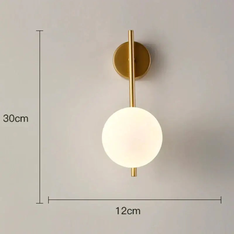 Modern minimalist gold and black wall lamp with glass gold led globe and slender cylindrical stem for bedroom decorbites glass gold