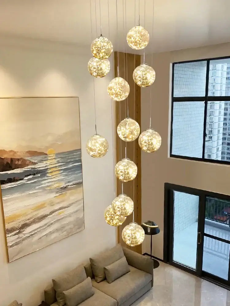 Modern minimalist gold decorbites glass chandelier with multiple warm glowing spherical orbs for staircase lighting