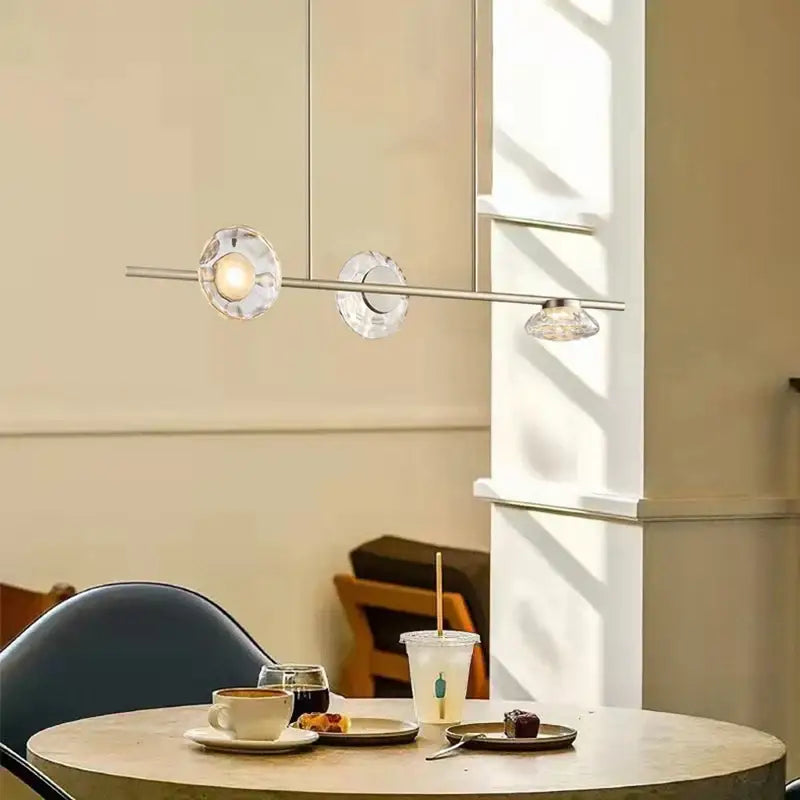 Modern minimalist gold glass led chandelier with three crystal glass shades suspended from a sleek rod