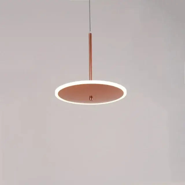 Copper-toned modern minimalist decorbites gold led pendant light with circular design and illuminated edge for kitchen island