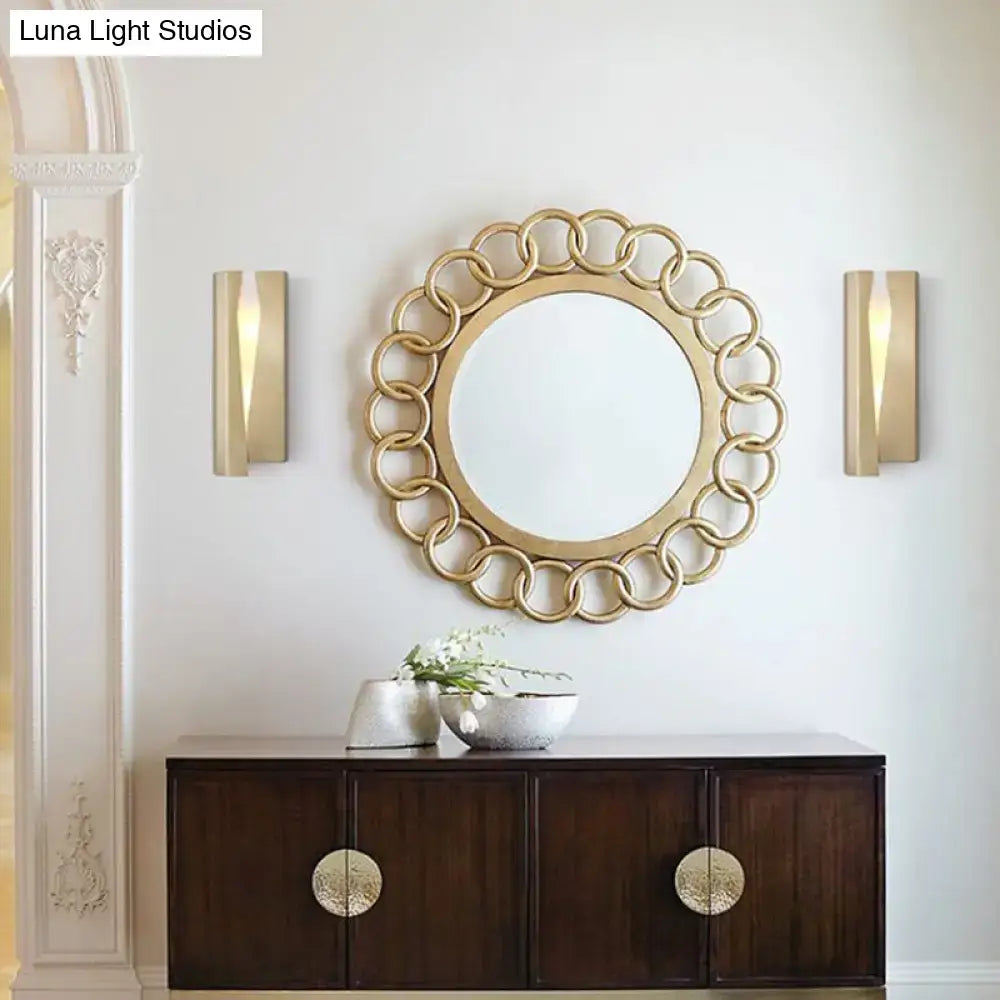 Modern minimalist gold metal rectangle wall sconce light with a gold-toned circular mirror and decorative interlocking rings frame