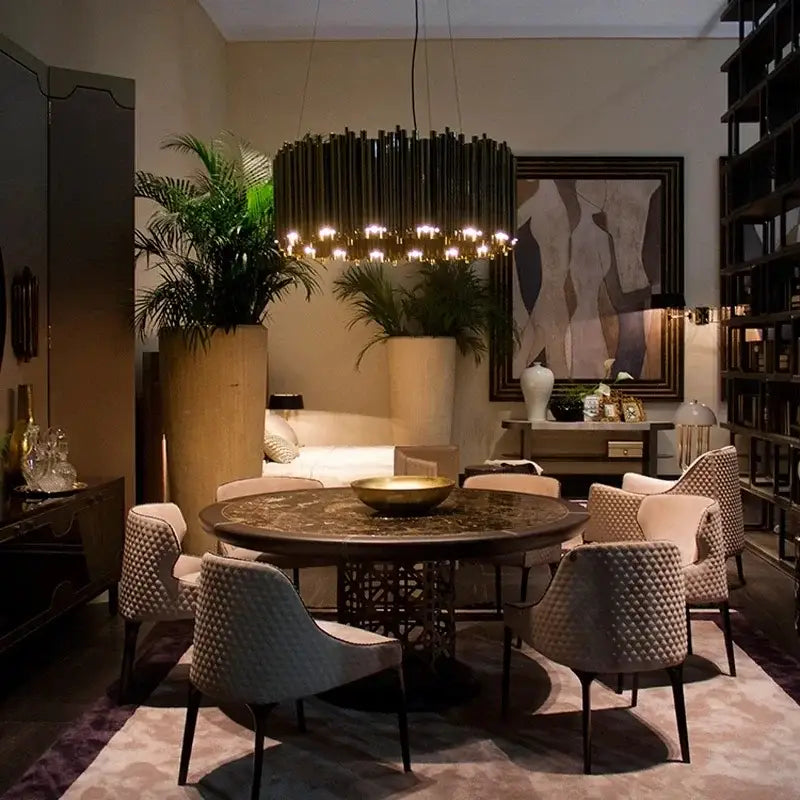 Round dark wood dining table with intricate inlaid patterns and a central golden bowl paired with a decorbites gold stainless steel chandelier