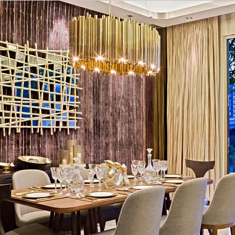 Modern minimalist gold stainless steel chandelier with a cascading design hanging above a dining table decorbites gold stainless