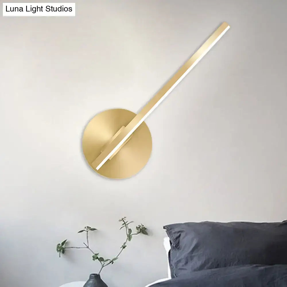 Modern minimalist gold tube stick wall sconce with a sleek circular base and elongated rectangular light bar for bedroom use