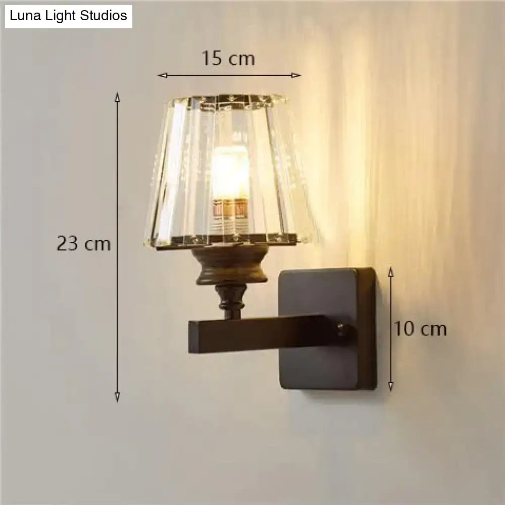 A modern minimalist wall lamp with a dark bronze base and fluted crystal glass shade for elegant bedroom lighting