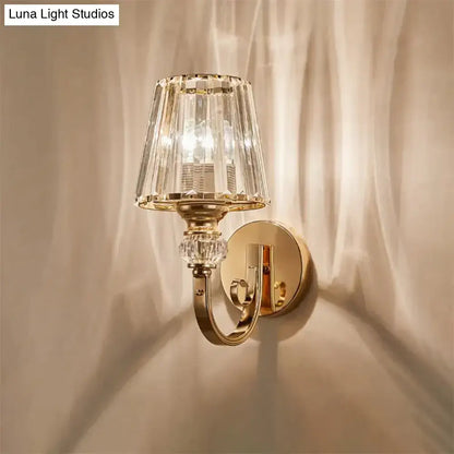 Modern minimalist gold wall lamp featuring a faceted crystal shade and decorative crystal accents for bedroom use