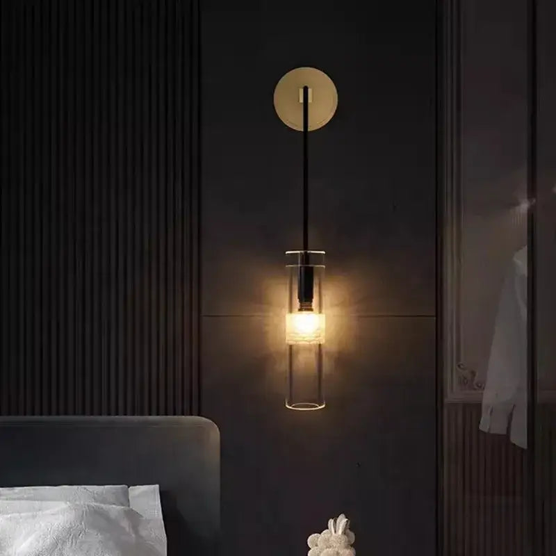 Modern minimalist wall lamp with circular gold-toned backplate black stem and clear glass cylinder for living room decorbites golden glass wall