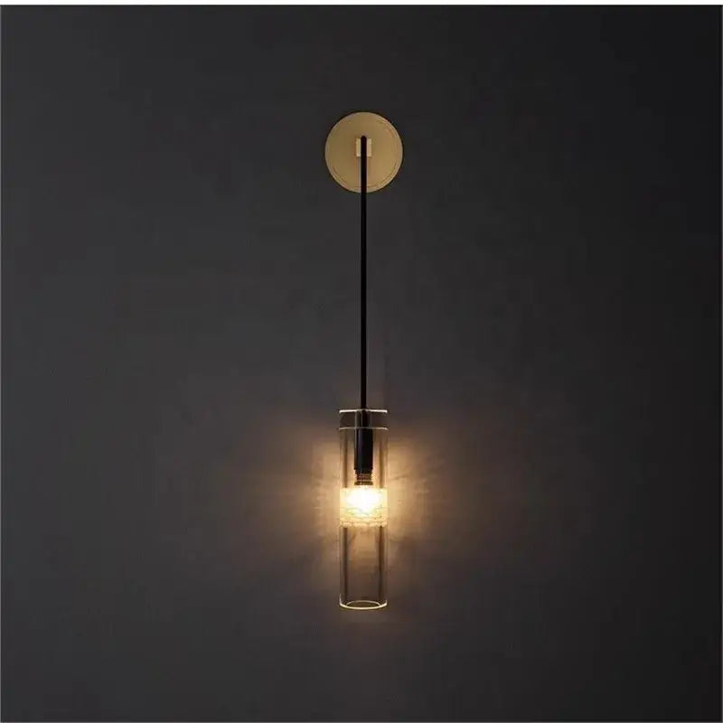 Modern minimalist golden glass wall lamp with clear glass cylinder, sleek black cord, and brass finish wall lamp decorbites golden glass