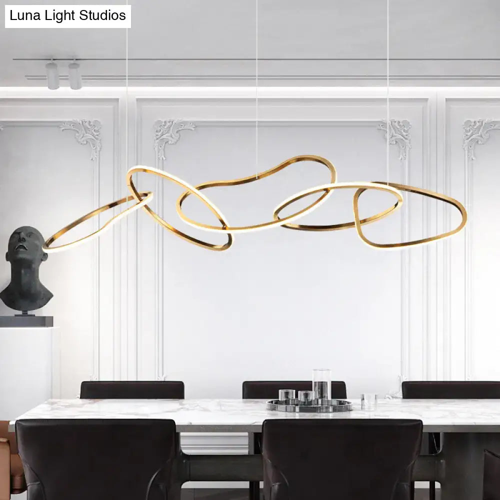 Modern minimalist golden led hanging light fixture with interconnected circular rings above a dining table