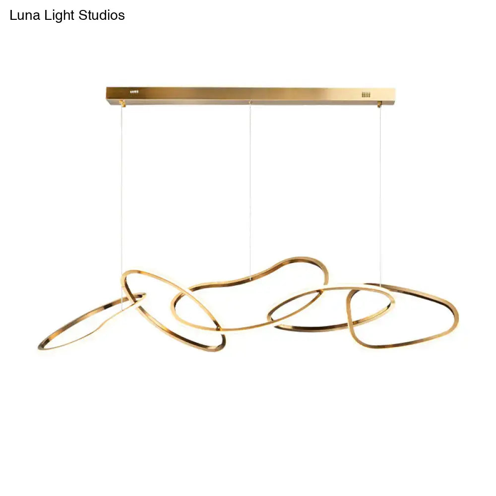 Modern minimalist golden led hanging light with sleek interlocking circular rings suspended from brass fixture for dining room