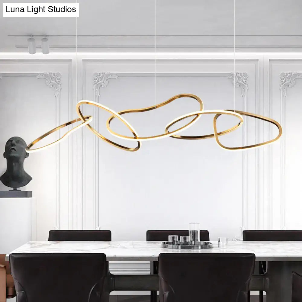 Modern minimalist golden led hanging light with interlocking circular rings above a dining table for dining room