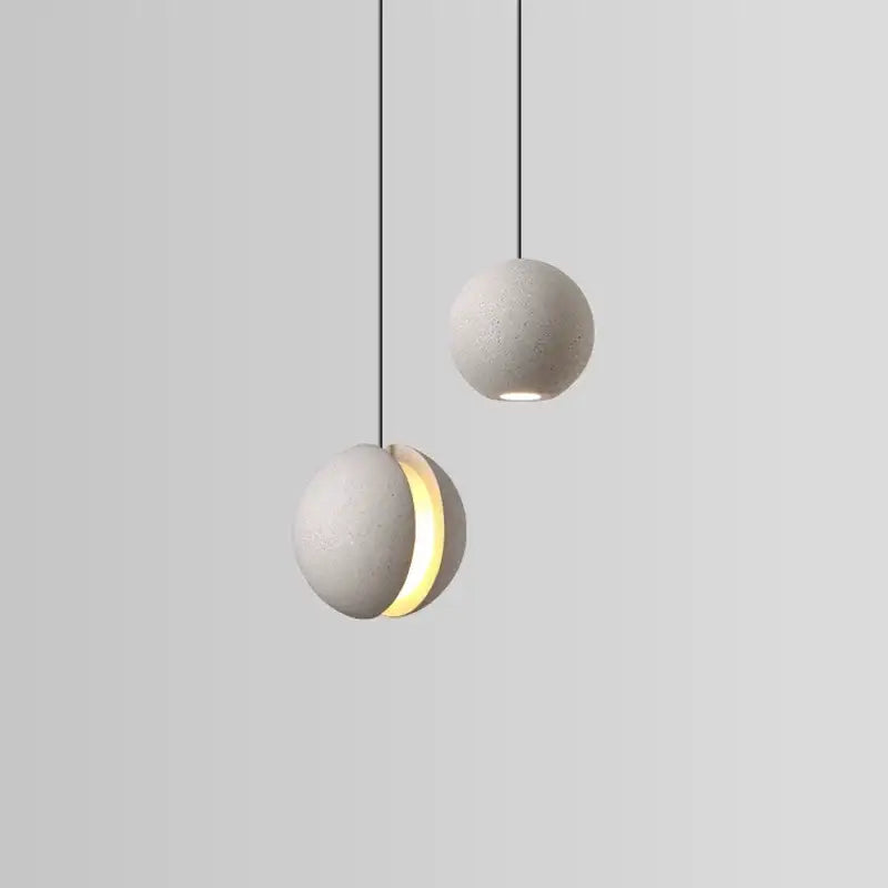 Modern minimalist gray and gold pendant light featuring cement planet chandelier design with matte gray concrete spheres and black cords