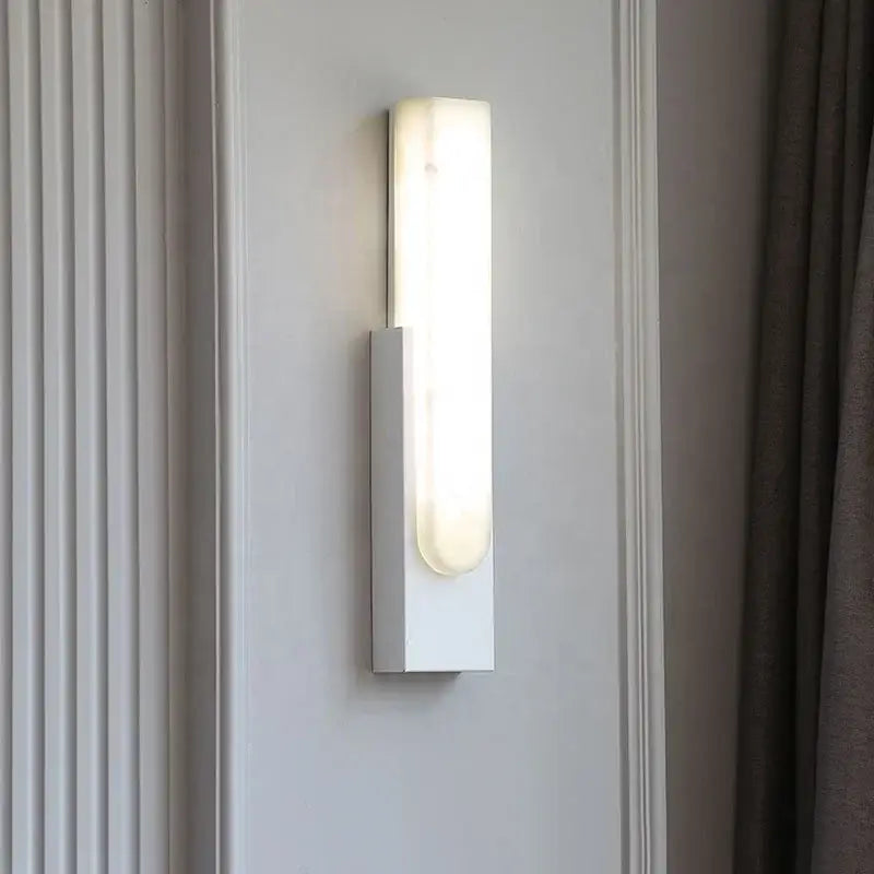 Modern minimalist grey metal wall sconce with frosted glass diffuser softly illuminating bedroom decorbites grey metal design