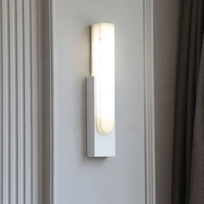 Modern minimalist grey metal wall sconce with frosted glass diffuser softly illuminating bedroom decorbites grey metal design