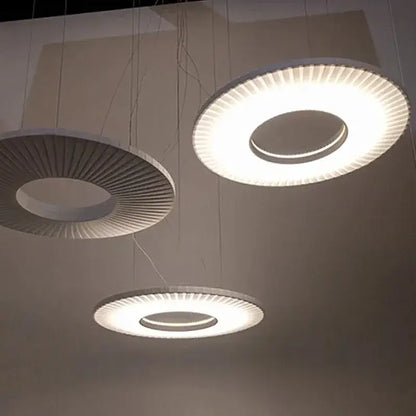 Modern minimalist dix iris pendant light with sleek white radial ribbed design emitting soft ambient illumination