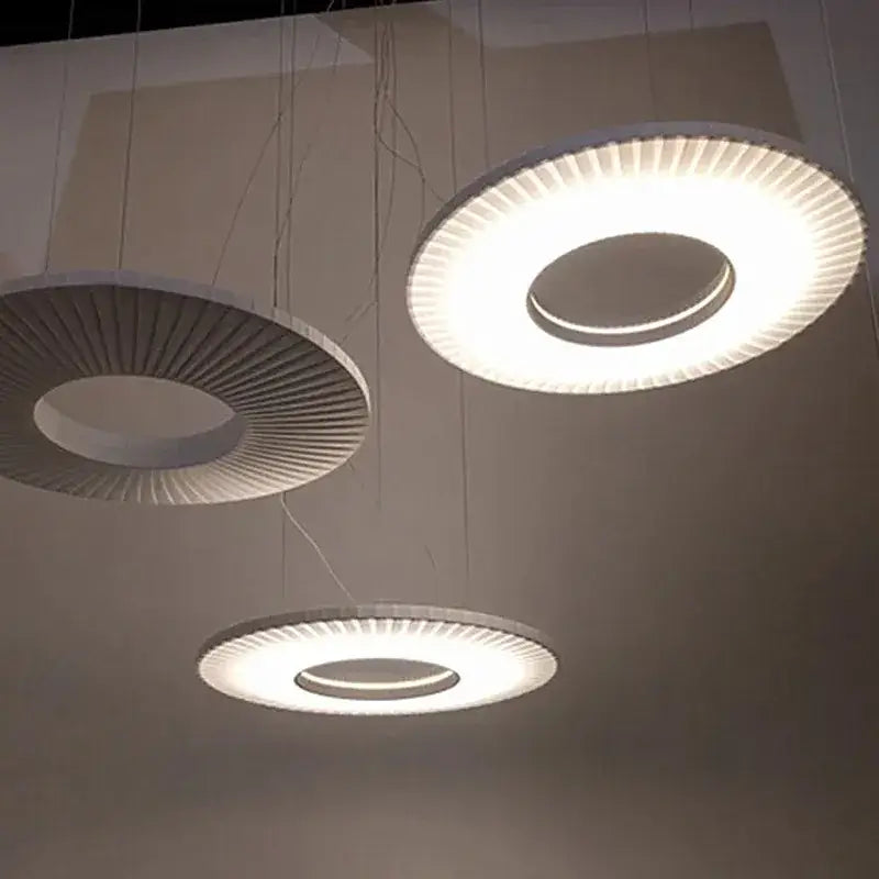 Modern minimalist dix iris pendant light with sleek white radial ribbed design emitting soft ambient illumination