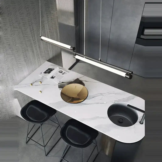Modern minimalist led black gold designer chandelier above a bar counter with white marble top black sink and gold bowl centerpiece