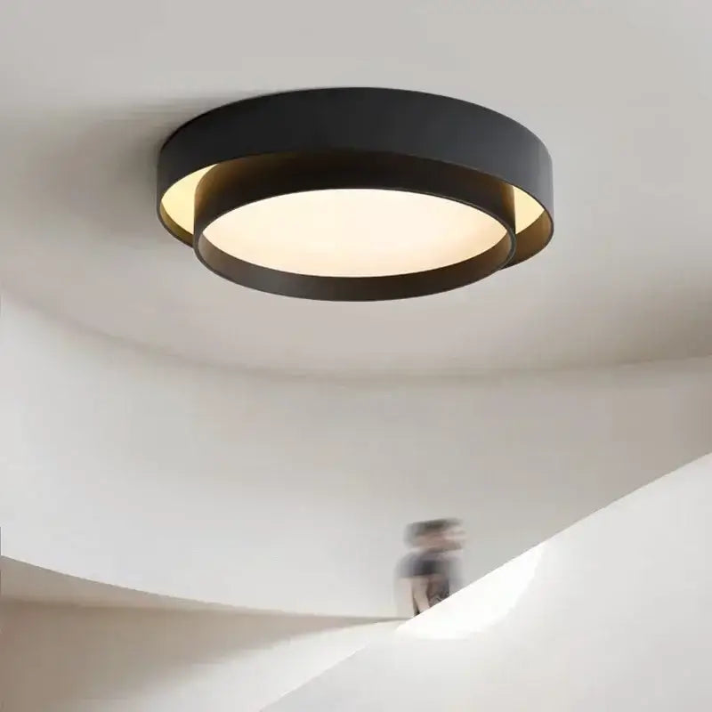 Modern minimalist black led ceiling light with circular concentric ring design and warm diffused glow for bedroom lighting