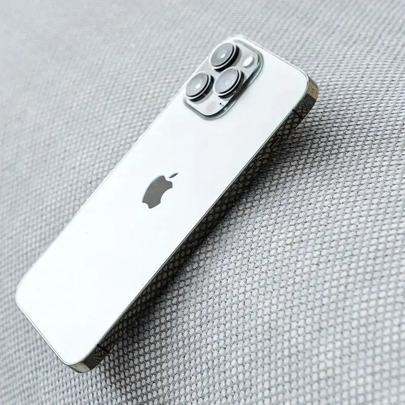 Silver iphone 13 pro with sleek reflective glass back and triple-camera system next to modern minimalist light green panda sofa mat