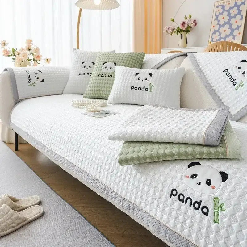 White quilted sofa cover with embroidered panda and bamboo designs and light green trim for modern minimalist living rooms