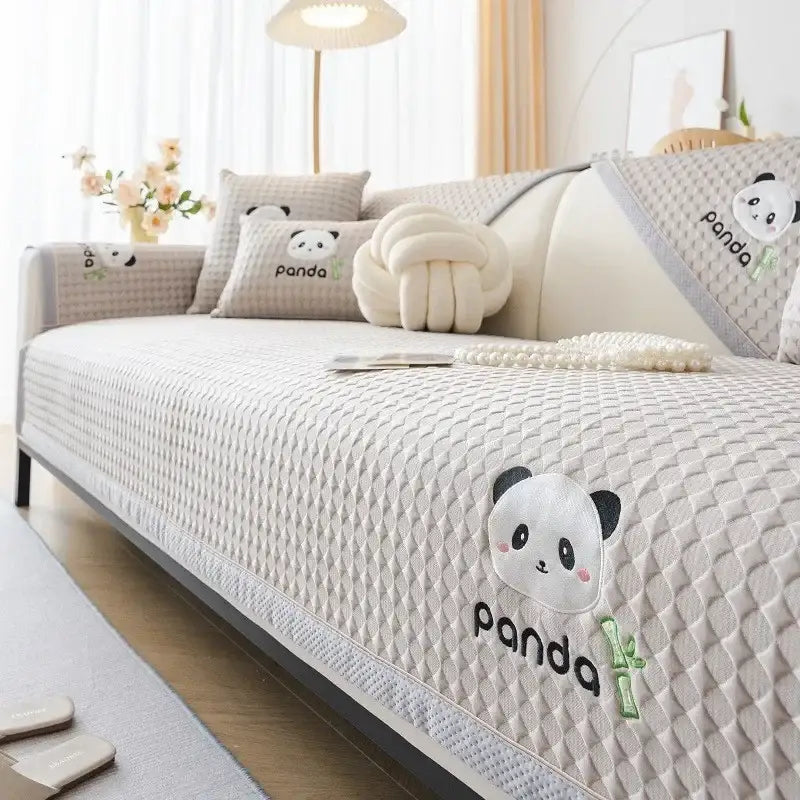 Beige quilted sofa cover with embroidered panda faces and bamboo details for modern minimalist living room seat