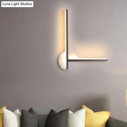 Modern minimalist linear wall light fixture with metallic frame and frosted white base emitting warm ambient light