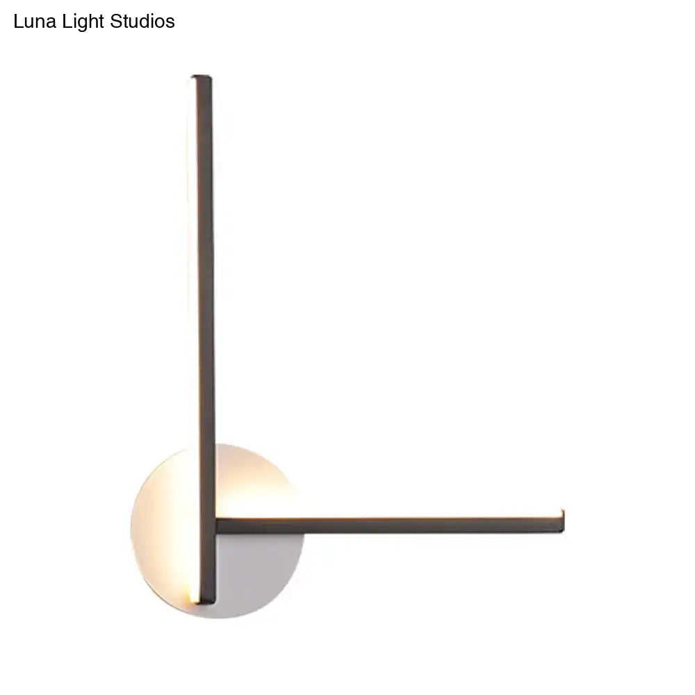 Modern minimalist linear wall light fixture with matte metal frame and circular base emitting warm ambient light for bedroom