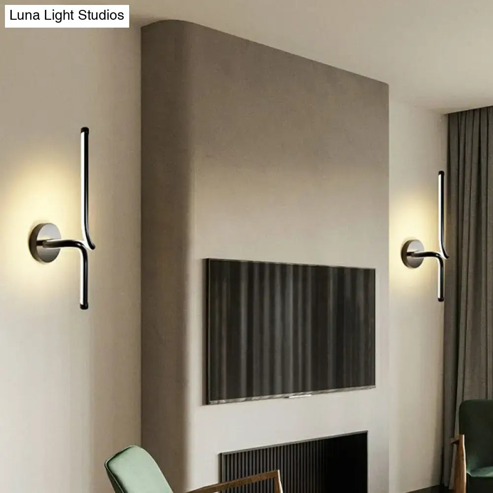 Modern minimalist black metal led wall sconce with sleek curved arms and circular bases for bedroom lighting