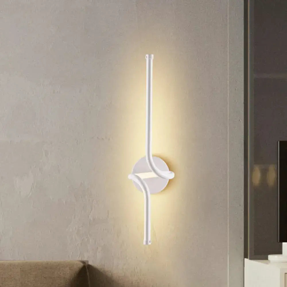Modern minimalist metallic led wall sconce in white with a sleek curved arm and circular base for bedroom linear light