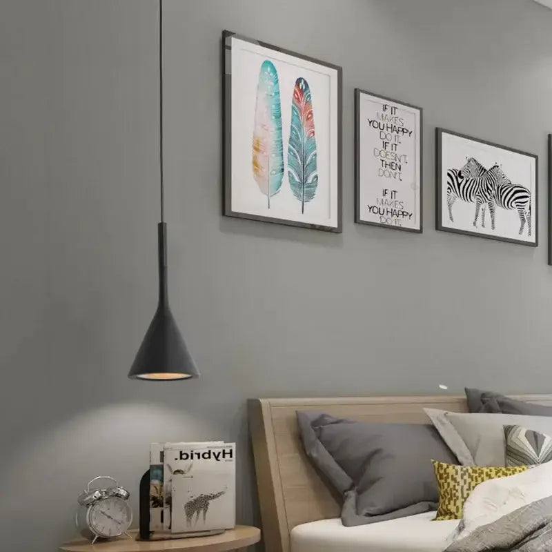 Black conical metal pendant light hanging above a wooden nightstand in a modern minimalist kitchen set
