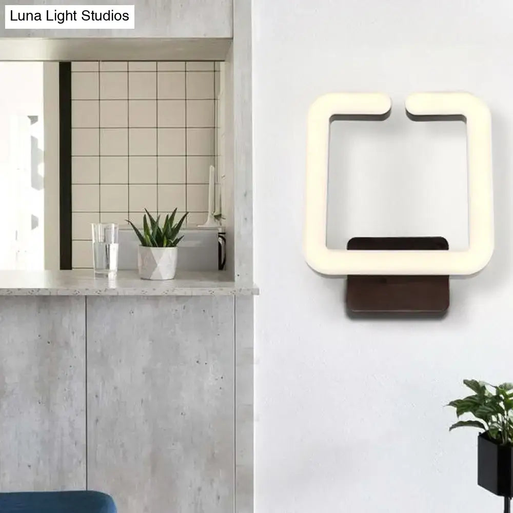 Modern minimalist off-white led wall sconce with dark brown base providing warm white natural light for bedroom use