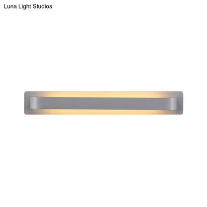 Modern minimalist silver rectangular wall lamp with sleek design and warm ambient lighting for living room use