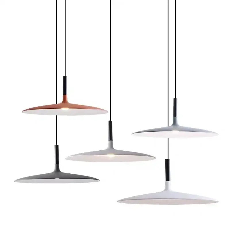 Modern minimalist ufo pendant lights with sleek matte copper white and gray disc shades suspended by black cords for dining room lighting
