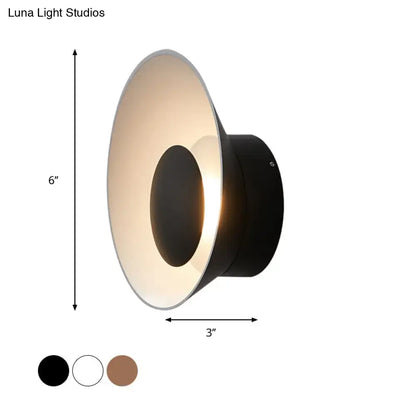 Black conical wall lamp with matte finish and warm diffused light for modern minimalist living room decor