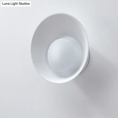 Modern minimalist white wall lamp with matte conical shade and integrated circular led light for living room use