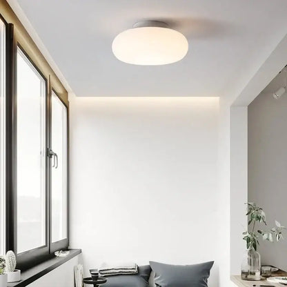 A sleek round modern minimalist white ceiling pendant lamp with a soft white diffuser for kitchen and bedroom