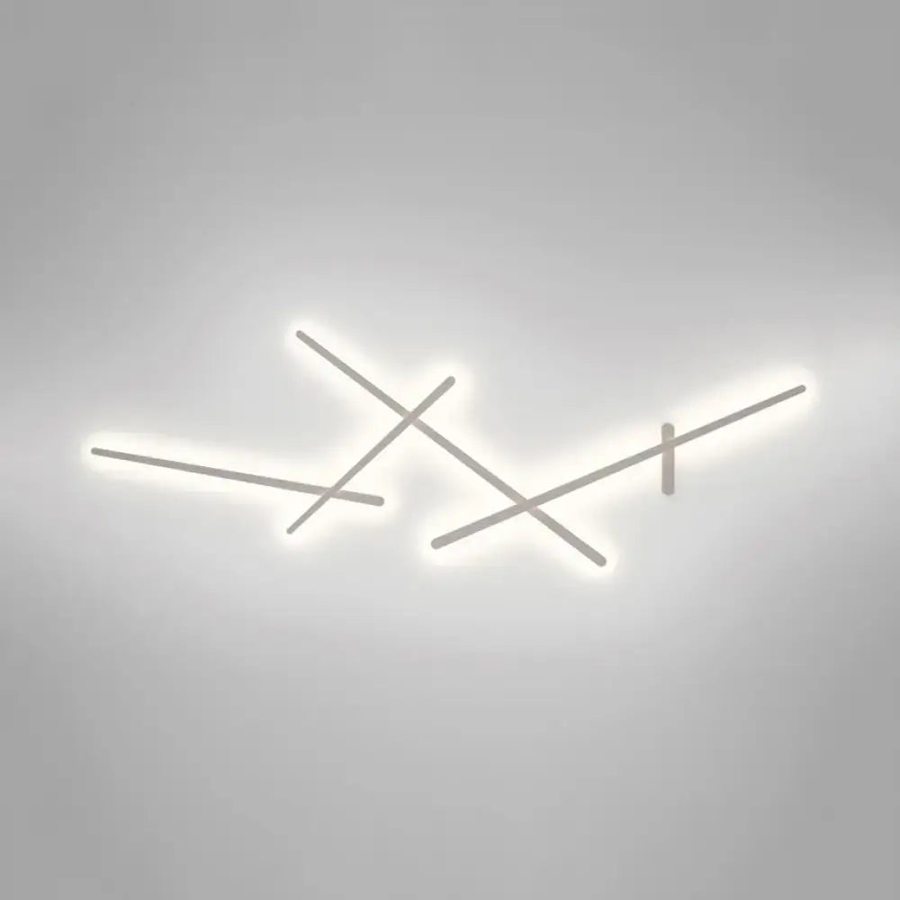 Modern minimalist white wall lamp with sleek intersecting metallic rods emitting soft white glow for living room