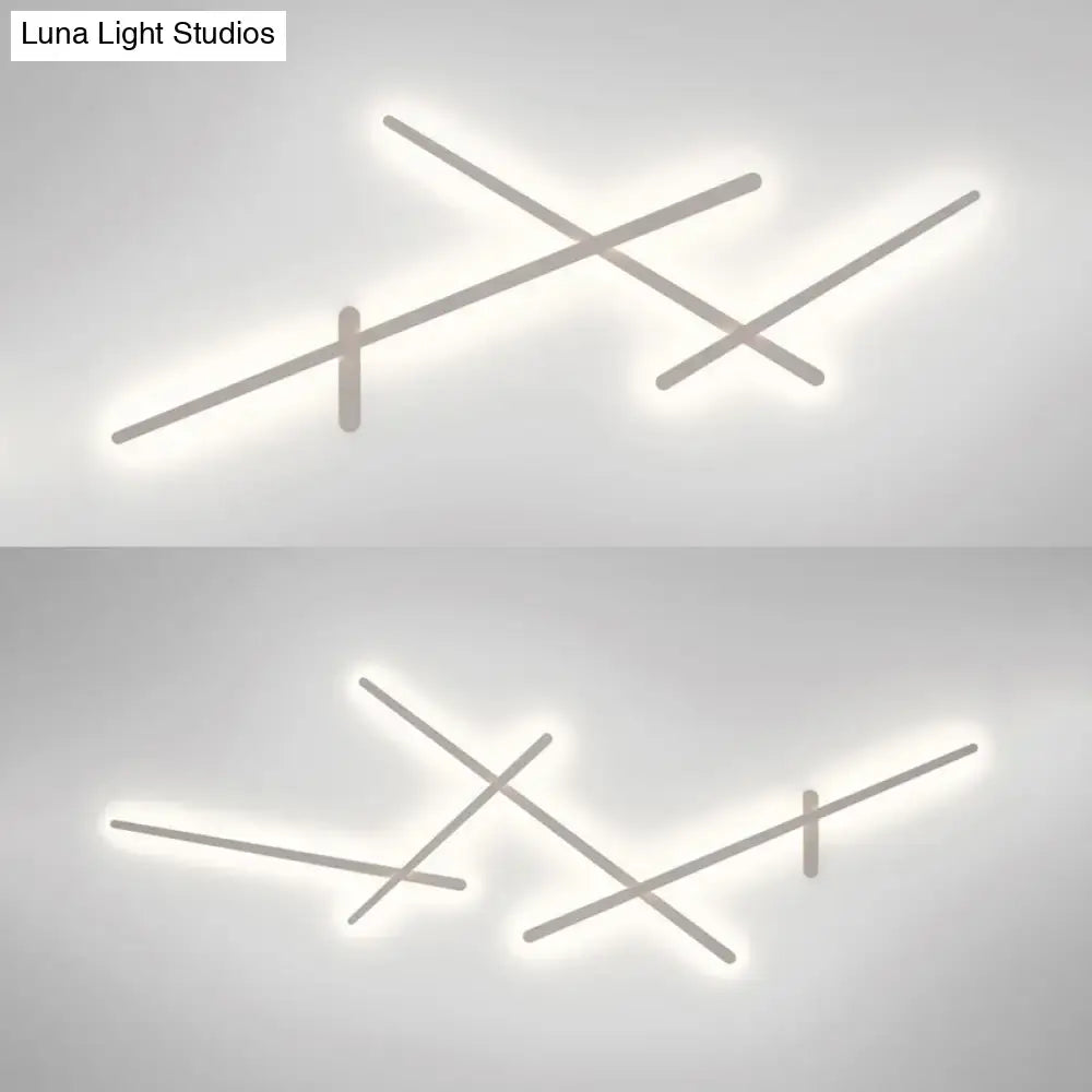 Modern minimalist white wall lamp with crossed linear arms and soft white LED glow for living room use