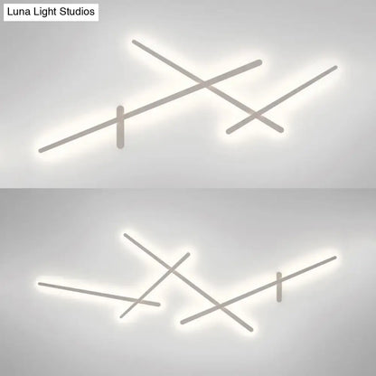 Modern minimalist white wall lamp with crossed linear arms and soft white LED glow for living room use