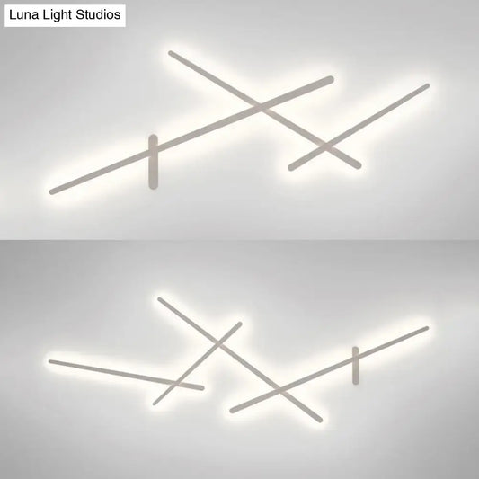 Modern minimalist white wall lamp with crossed linear arms and soft white LED glow for living room use