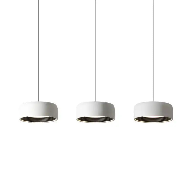 Three minimalist white cylindrical pendant lights with dark inner rims in decorbites designer led chandelier for dining room decor